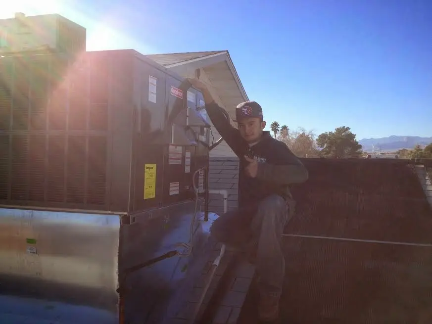 HVAC technician performing AC Tune-Up on a rooftop unit in Draper